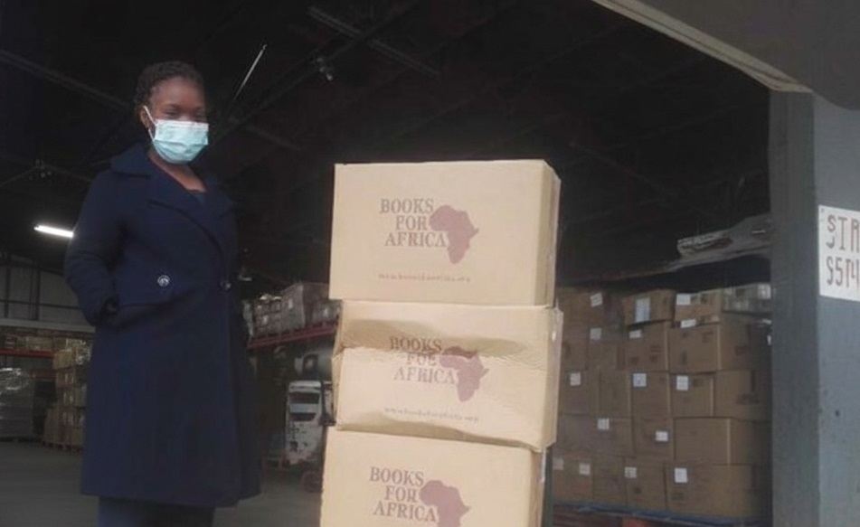 Children smiling with books donated by Cross and Crown Foundation